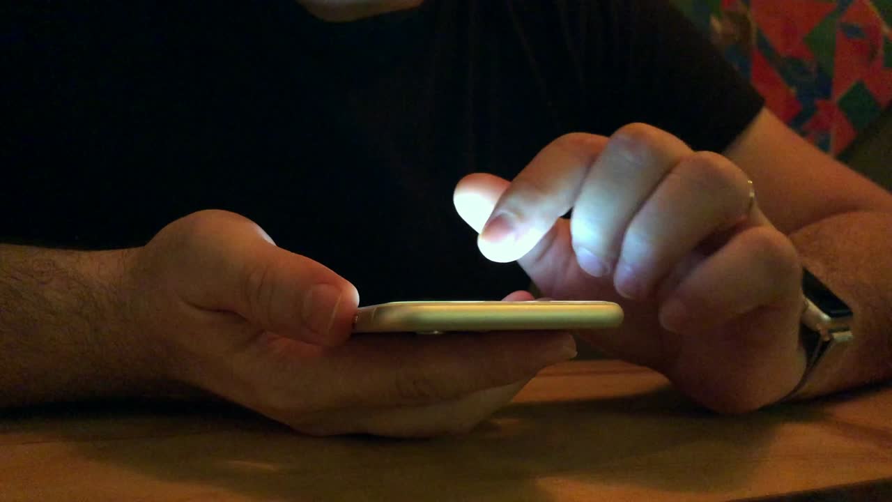 mano con teléfono móvil en el café