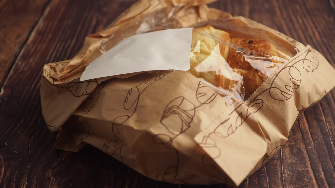 Fresh Croissants in a Paper Bag on a Wooden Table