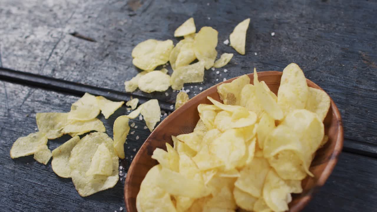 Close up view of potato chips in a bowl with copy space on wooden surface