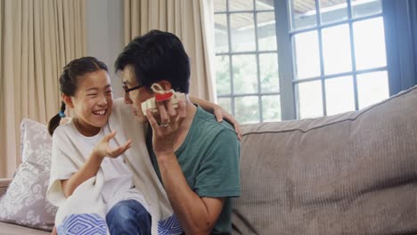 daughter giving gift box to father in living room 4k