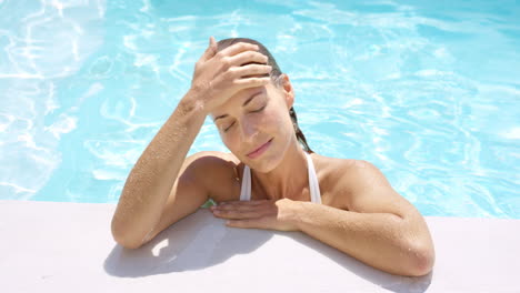 Mujer-Atractiva-Relajándose-En-El-Borde-De-La-Piscina.