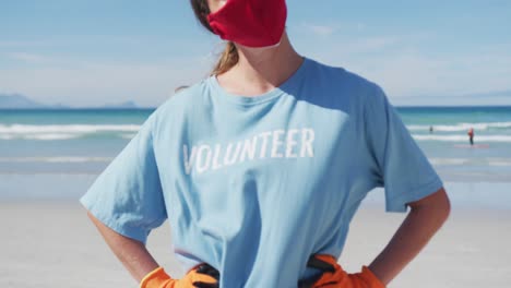 Portrait-of-caucasian-woman-wearing-volunteer-t-shirt-and-face-mask-looking-at-camera