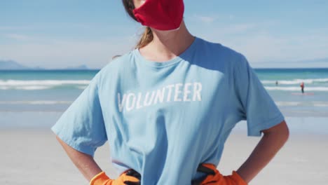 portrait of caucasian woman wearing volunteer t shirt and face mask looking at camera