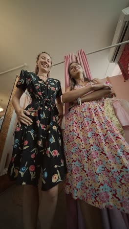 two women in floral dresses posing indoors