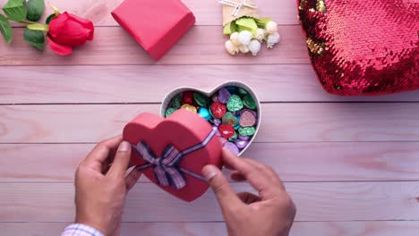 caja de regalos en forma de corazón en una mesa de madera