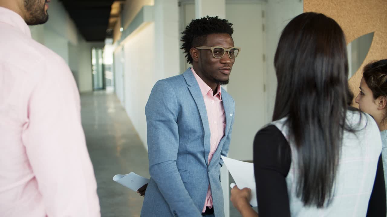 Smiling man shaking hands with colleagues