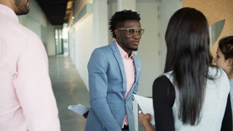 smiling man shaking hands with colleagues