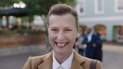 portrait of elegant mature business woman laughing cheerful in urban background wearing stylish suit jacket