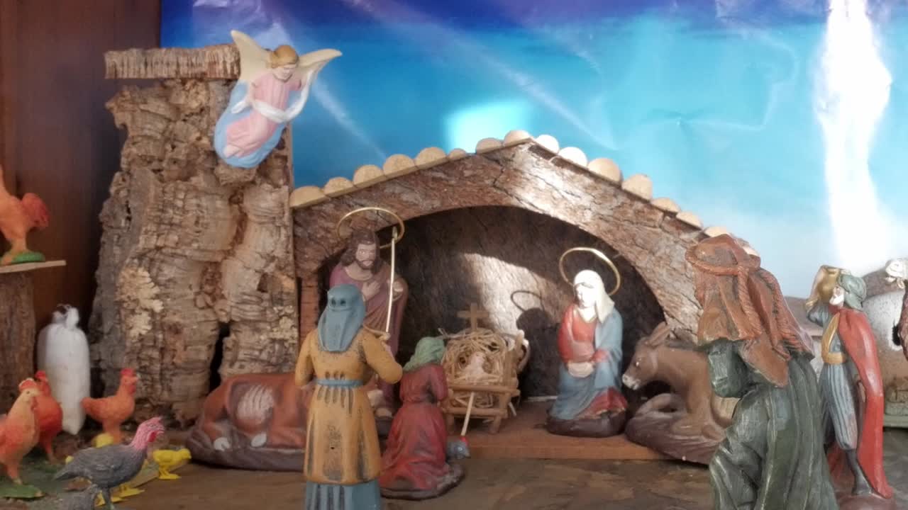 A nativity scene with figurines of Mary, Joseph, baby Jesus, animals, and an angel