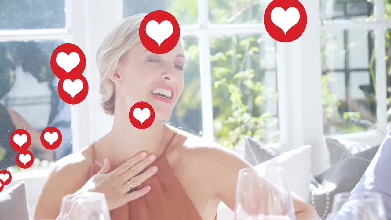 Animation of heart icons floating around smiling woman during lunch