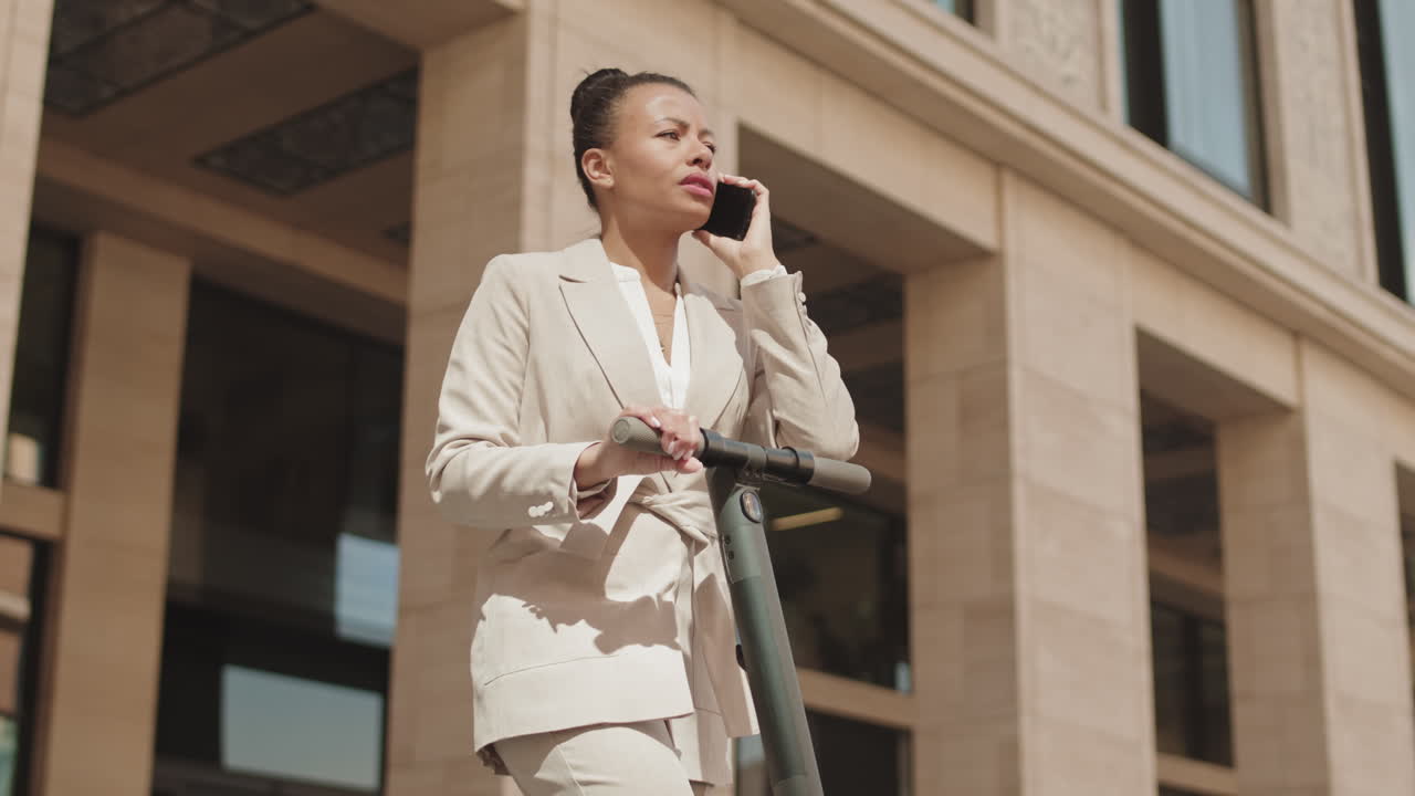 Businesswoman with E-Scooter Making Phone Call Outdoors