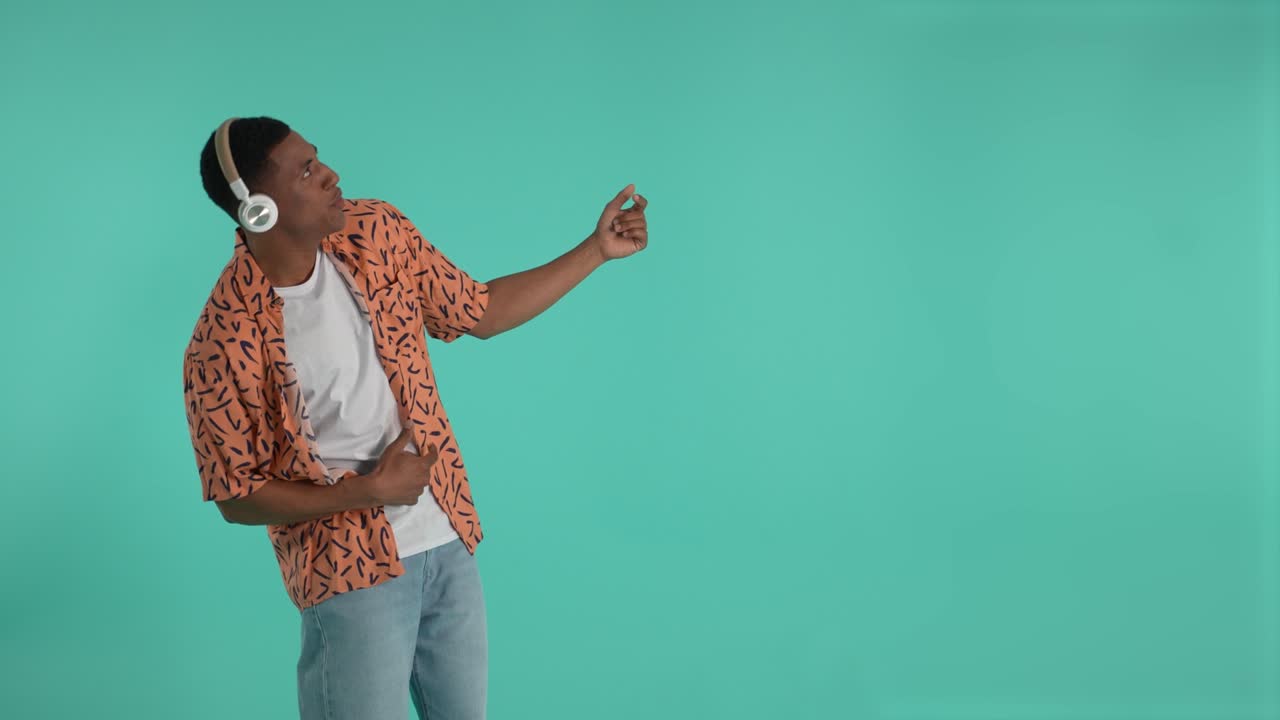 Joyful young male listening to music and dancing
