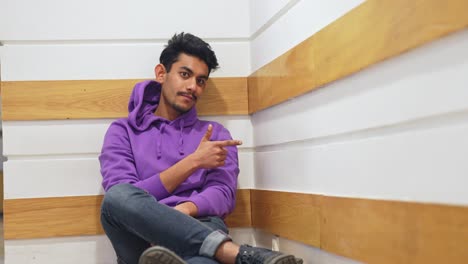 Cool-Sri-lankan-exchange-student-sitting-on-bench-indoors-at-university