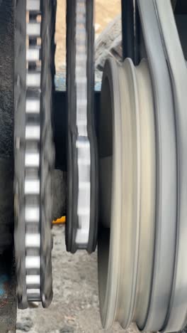 chains and belts driving a motor on a industrial construction concrete mixer, close up vertical shot.