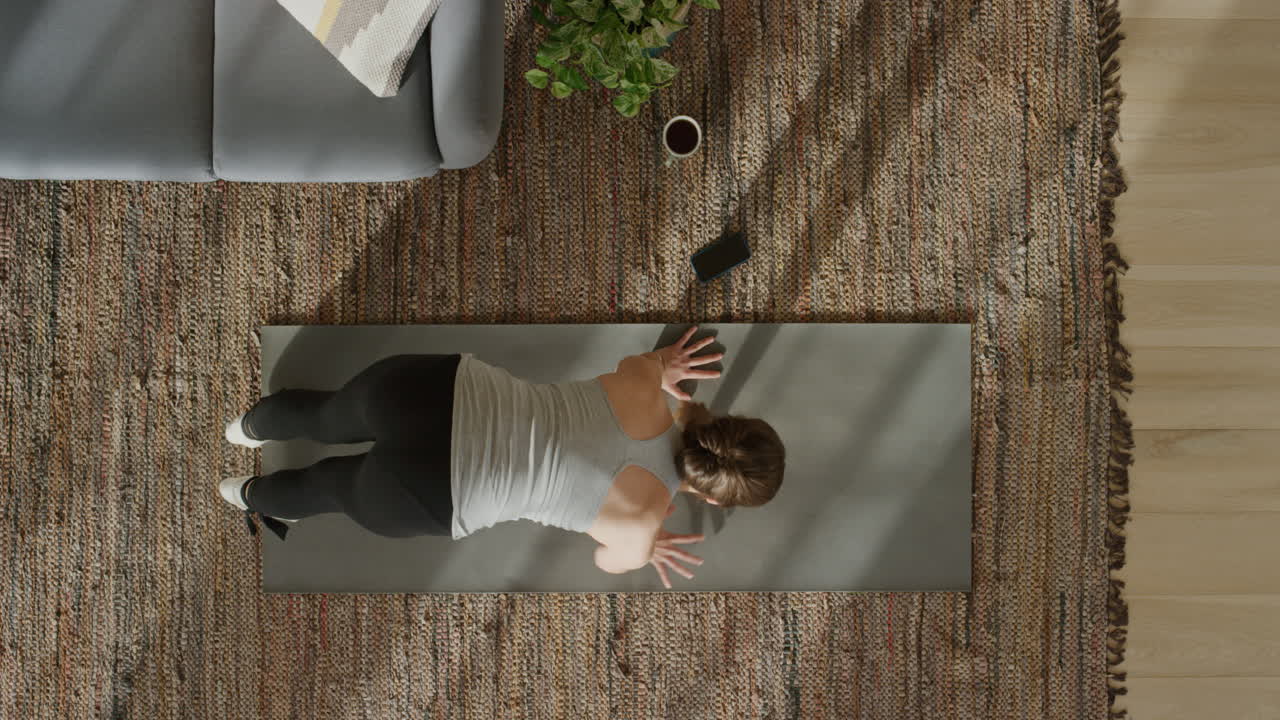 vista superior de una mujer de yoga practicando la postura del perro boca abajo ejerciendo un estilo de vida saludable en casa sobre una colchoneta de ejercicios disfrutando de la meditación consciente.