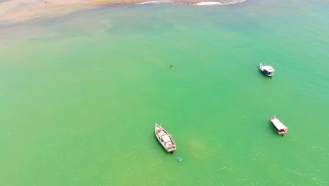 aerial footage passing by some fishing boats in itapuã - bahia - brazil