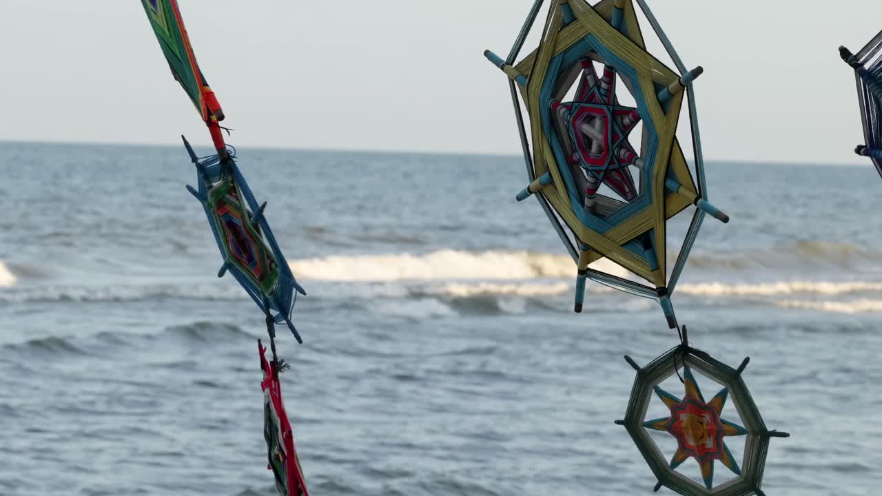 Vibrant wind spinners dance gracefully against the backdrop of gentle ocean waves.