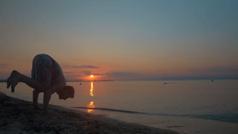 hombre haciendo handstand en la playa al atardecer