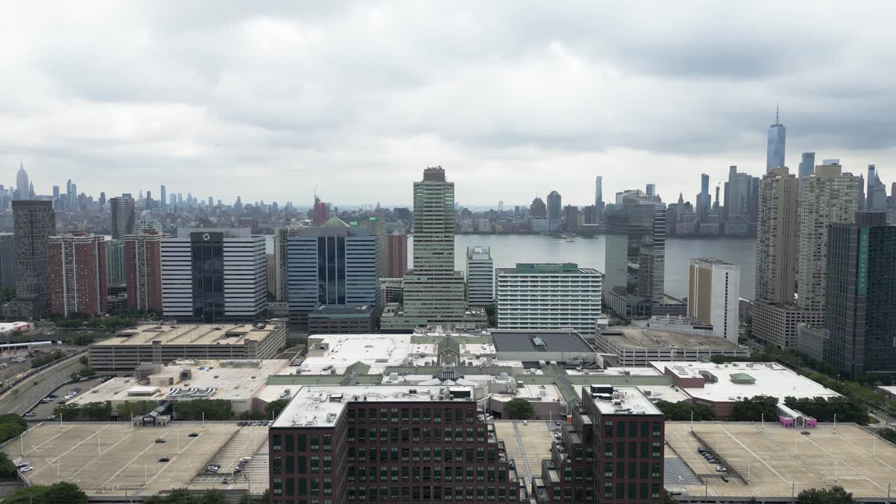 Drone flying toward New York City and Jersey City skyline over water with urban landscapes and skyline views, ideal for travel, lifestyle, real estate, and city branding visuals