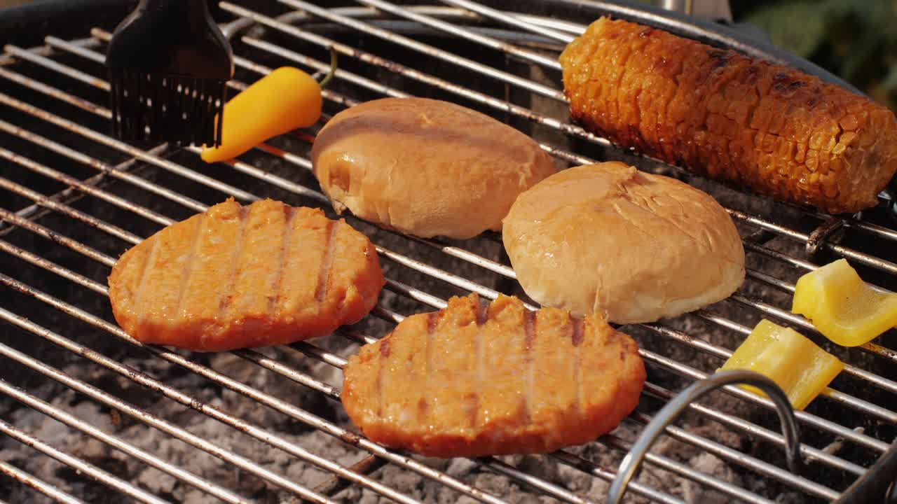 Veggie orange burger on grill, carrot and oats burger with corn and yellow pepper, vegetarian food barbeque, potato grill burger.