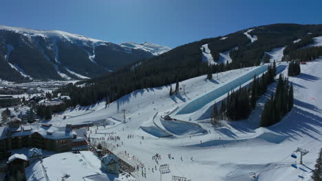 Drone-aerial-Copper-Mountain-winter-ski-snowboard-resort-half-pipe-training-practice-tricks-competition-Colorado-early-morning-sunlight-fresh-snow-unique-birds-eye-cinematic-forward-pan-up-motion-4k