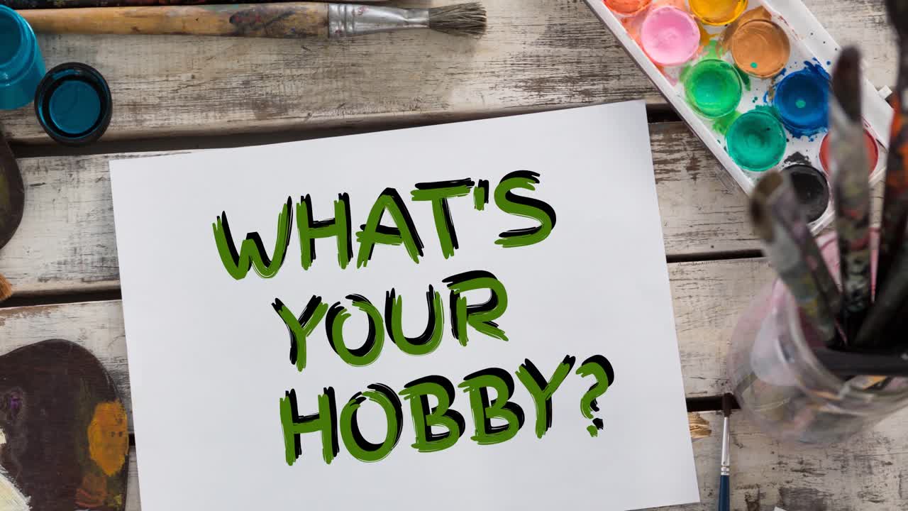 Animation of what's your hobby text in green, with watercolour paints and paintbrushes on table top