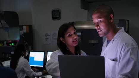 Two scientists discussing over laptop 4k
