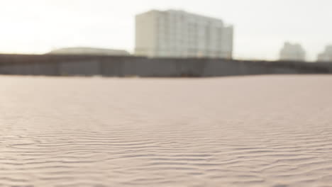 Early-morning-empty-beach-against-city-buildings