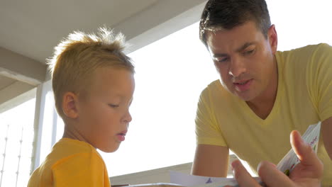 father and child spending leisure with book