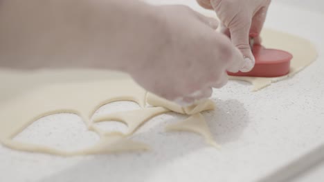 cutting out heart shaped butter cookies in a pastry shop using a cookie cutter, 4k