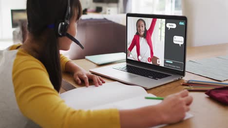 Schoolgirl-using-laptop-for-online-lesson-at-home,-with-her-colleague-and-web-chat-on-screen