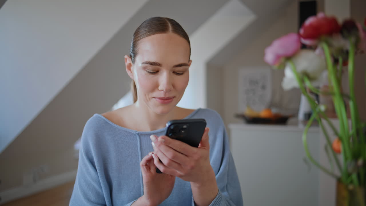 Homely businesswoman watching smartphone social media in sunlit room closeup