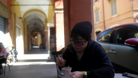 man drinking coffee in an outdoor cafe