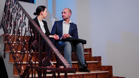 job partners discussing sitting on stairs in corporate business