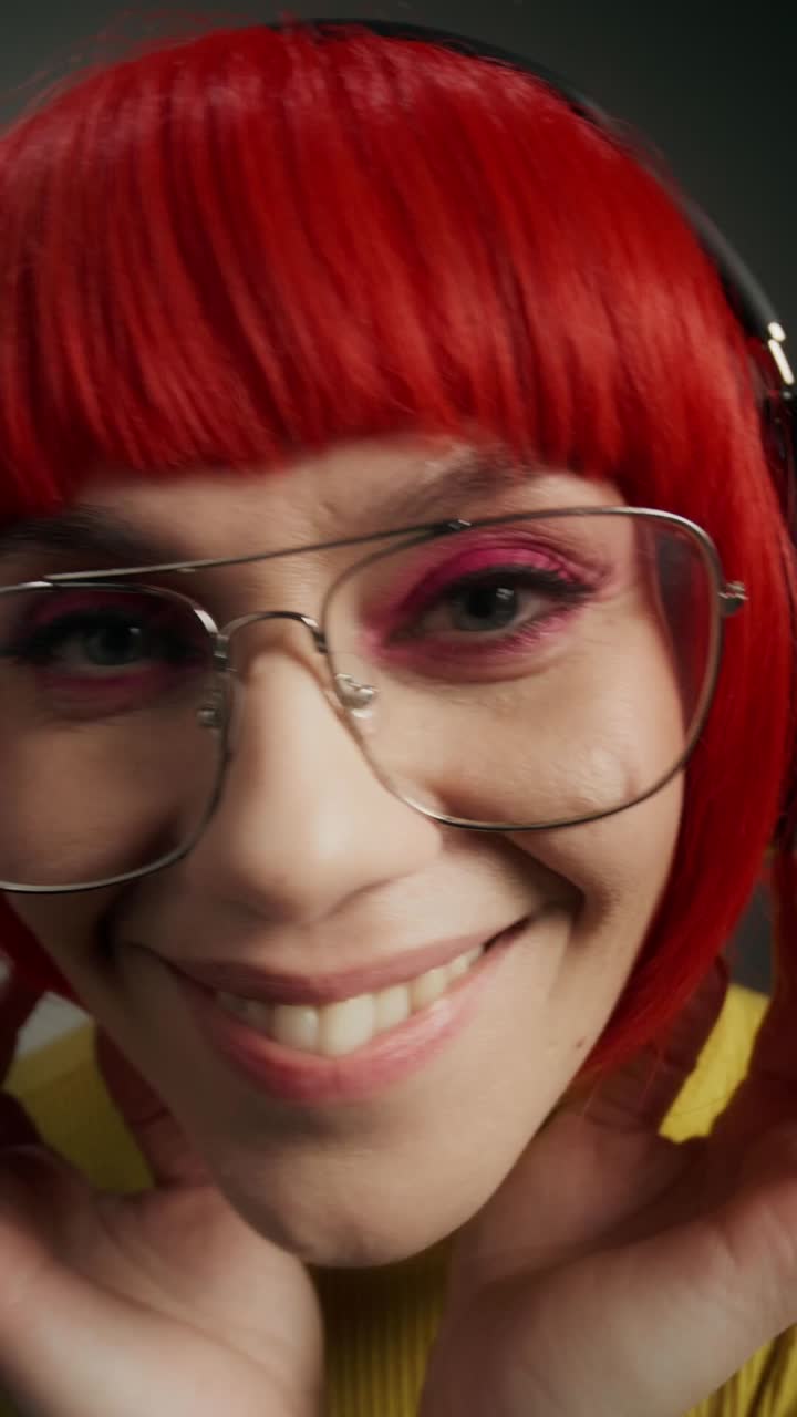 mujer de cabello rojo y gafas con auriculares