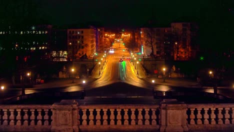 Verkehr-In-München-Bei-Nacht-Mit-Blick-Auf-Die-Beliebte-Prinzregentenstraße-Im-Zentrum-Der-Bayerischen-Landeshauptstadt---Fahrende-Autos-Halten-An-Ampeln-An-Und-Fahren-Mit-Sanftem-Zoom-Out-Effekt