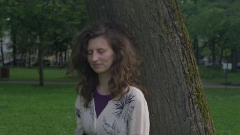 Joven-Hermosa-Mujer-Caminando-Y-Alrededor-De-Un-árbol-Y-Apoyándose-En-él-De-Una-Manera-Juguetona-Y-Nostálgica