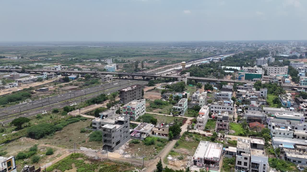 Aerial view of a highway intersecting the green countryside with railway station in the background of Amaravathi, Vijayawada.