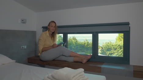 Woman-sitting-in-room-with-tablet