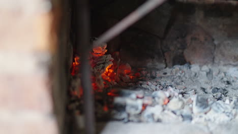 embers and ashes glowing inside brick fire pit for making traditional asado argentino.