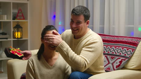beautiful woman with eyes covered receiving a gift