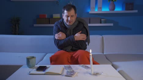 el hombre tiene frío en casa. el hombre que mira la factura de gas natural tiene frío en casa.