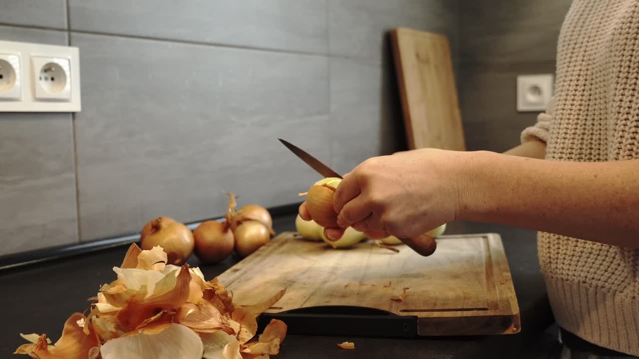 Kitchen Scene: Woman Peeling Onions on Wooden Board