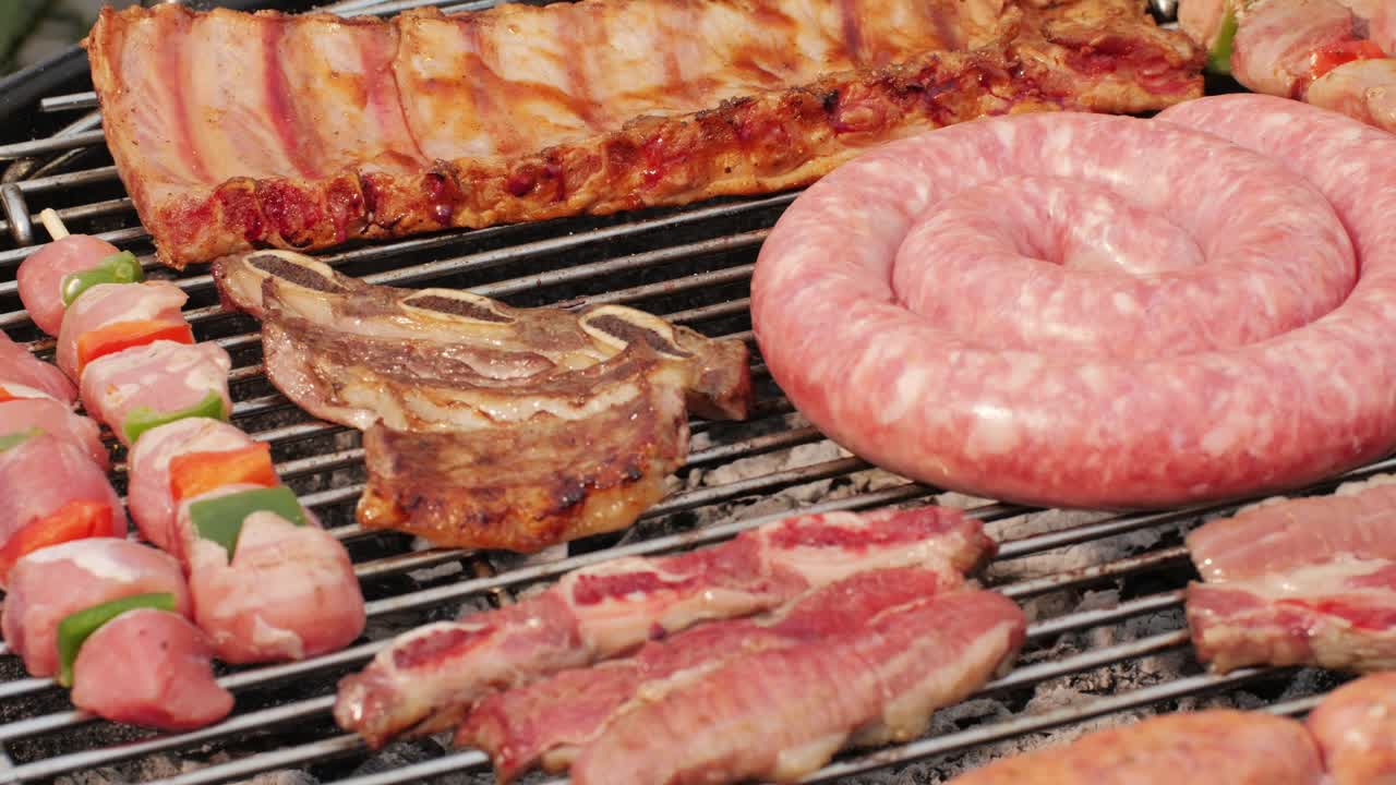Traditional spanish barbeque, big sausage chorizo botifarra, pork and beef ribs on grill with fire, american style cooking, chef grilling meat fat food, steaks and sausages on bbq. High quality 4k footage