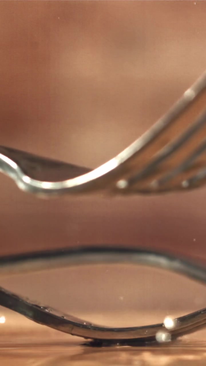 Slow Motion Close-up of a Fork Dropping and Splashing Water