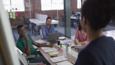 Happy-mixed-race-business-colleagues-sitting-having-a-discussion-in-meeting-room-clapping