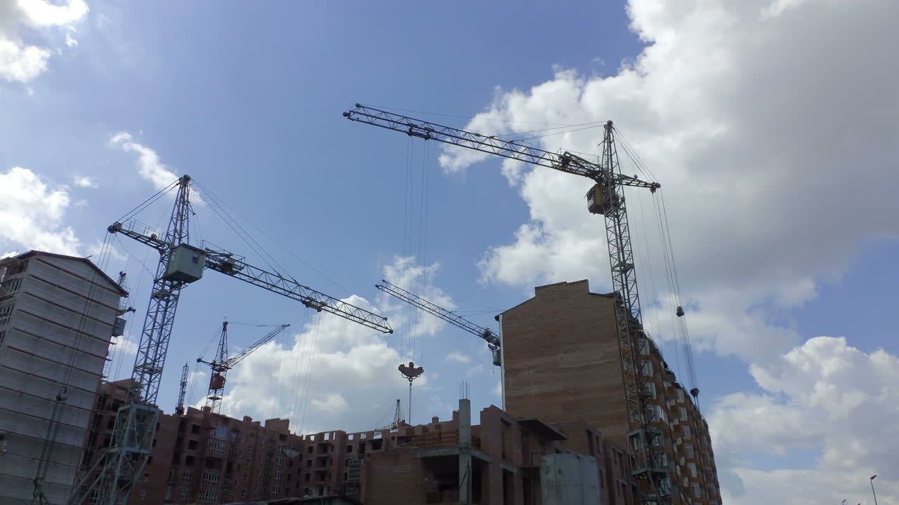 Construction of residential buildings. Construction cranes over houses. Timelapse