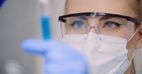 el médico gotea cuidadosamente el medicamento de la pipeta en tubos de vidrio de muestra para el análisis de adn en el laboratorio 4
