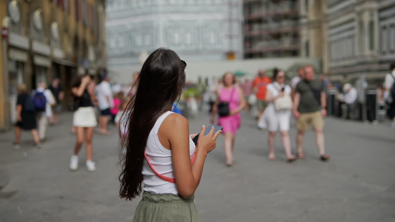혼잡 한 도시 거리에서 사진 을 찍는 여자