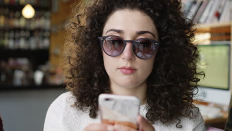 mujer con cabello rizado usa teléfono inteligente